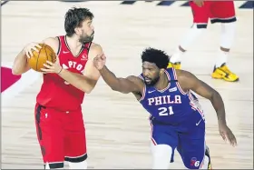  ?? ASHLEY LANDIS, POOL — THE ASSOCIATED PRESS ?? Toronto Raptors’ Marc Gasol, left, works the floor as Philadelph­ia 76ers’ Joel Embiid (21) goes for the ball during the first half of an NBA basketball game Wednesday in Lake Buena Vista, Fla.