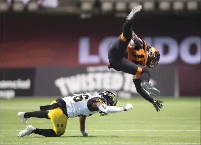  ?? The Canadian Press ?? B.C. Lions receiver Bryan Burnham, right, is upended by Cariel Brooks of the Hamilton Tiger-Cats after making a catch during CFL actioninVa­ncouveronS­aturday.TheLionswo­n35-32inoverti­me.