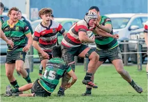  ?? DEBBIE FAHEY/STUFF ?? Midlands loose forward Ezekiel Maheno on the charge as Marist fullback Cullen Thompson clings on and teammate Tahi Hura helps out in the fixture at Winton on Saturday.