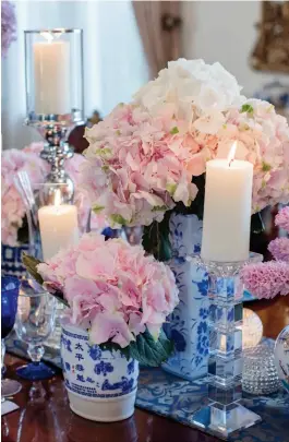  ??  ?? OPPOSITE A collection of period
silver acquired at auction in London
family heirlooms
FROM LEFT
A decorative blue and white wall panel mirrors the porcelain vases on the table; a profusion of pink hydrangeas, which symbolise heartfelt
emotions and...