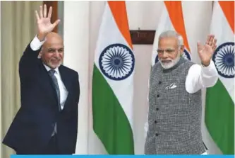  ?? —AFP ?? NEW DELHI: Indian Prime Minister Narendra Modi (right) and Afghan President Mohammad Ashraf Ghani wave to the media before a meeting in New Delhi yesterday. Ghani is on an official visit to India for a day.