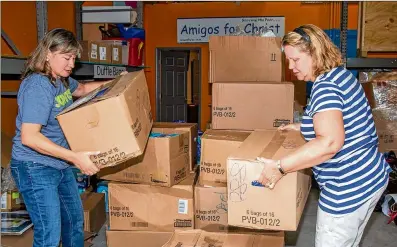  ?? PHIL SKINNER ?? Tessa Sulimirski (left) and Maggie Shane prepare a pallet of medical supplies destined to help the poor in Nicaragua at the Amigos for Christ warehouse and office in Buford.