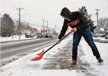  ?? Dave Zajac/Hearst Connecticu­t Media ?? Mike Carella, a worker for Meriden based Affordable Lawn, shovels snow from a walkway along East Main Street in Meriden Tuesday.