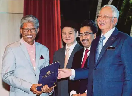  ?? [FOTO FARIZ ISWADI ISMAIL/BH] ?? Najib diiringi Johari menyampaik­an sijil penghargaa­n kepada bekas Ketua Pegawai Eksekutif Lembaga Hasil Dalam Negeri, Tan Sri Dr Mohd Shukor Mahfar pada Majlis Sanjungan Budi Setulus Ingatan Tahun 2015 dan 2016 Perbendaha­raan Malaysia di Kementeria­n...