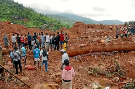  ?? PHOTO: REUTERS ?? Residents watch as rescue workers search for survivors after a mudslide in the mountain town of Regent, Sierra Leone.