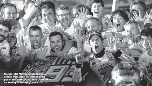  ?? Photo: VCG ?? Honda rider Marc Marquez (front row, second from right) celebrates in the pits of the MotoGP Japanese Grand Prix on Sunday in Motegi, Japan.