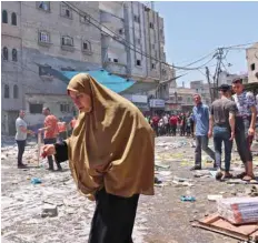  ?? — AFP ?? A Palestinia­n woman walks amidst the rubble following an Israeli strike on Rafah in the southern Gaza Strip.