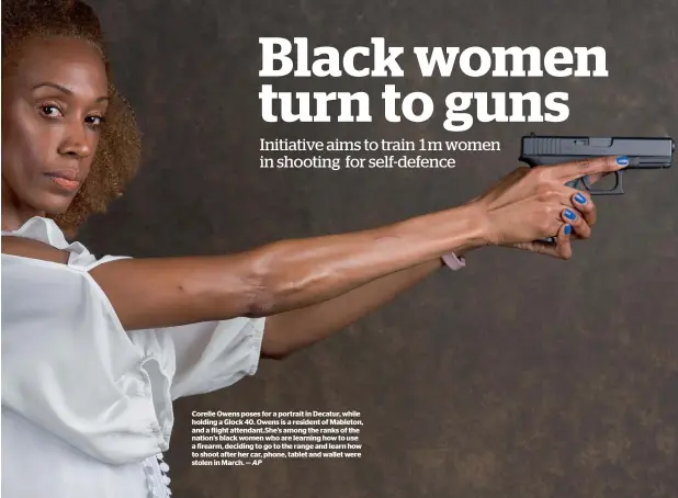  ?? AP ?? Corelle Owens poses for a portrait in Decatur, while holding a Glock 40. Owens is a resident of Mableton, and a flight attendant.She’s among the ranks of the nation’s black women who are learning how to use a firearm, deciding to go to the range and...