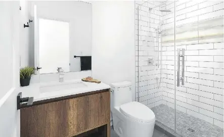  ??  ?? The main floor bathroom features walnut accents and ceramic tile.