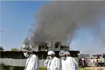  ?? AFP ?? Funcionári­os deixam o prédio do Serum Institute, na Índia, após incêndio; ao menos cinco pessoas morreram