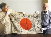  ?? Don Ryan / Associated Press ?? Obon Society co-founder Rex Ziak (left) and World War II vet Marvin Strombo display the battlefiel­d flag Strombo took from a dead Japanese soldier in the Pacific more than 70 years ago.