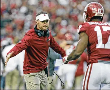  ?? BRETT DEERING / GETTY IMAGES ?? First-year Oklahoma coach Lincoln Riley congratula­tes wide receiver Jordan Smallwood after a touchdown against West Virginia. Riley leads the Sooners against Georgia in the College Football Playoff.