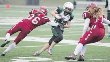  ?? KAYLE NEIS ?? Valkyries running back Samantha Matheson goes to move the ball past Riot linebacker Adrienne Zuck, left, and defensive line Chantal Vogel during the game at SMF Field in Saskatoon on May 13.