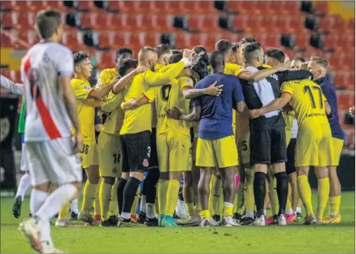  ??  ?? Los jugadores del Girona se abrazan tras el partido para celebrar su importante victoria en Vallecas.