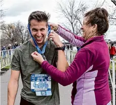  ?? Photos by Jim Franco/Times Union ?? Michelle Jones gives Mathew Czarnecki his medal after he finished the Helderberg to Hudson Half Marathon on Saturday.