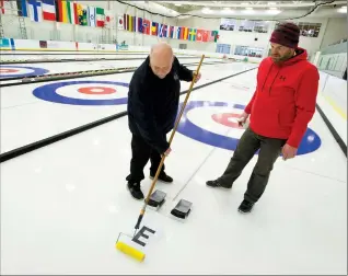  ?? Herald photo by Ian Martens ?? Chief ice technician Jamie Bourassa and Lethbridge Curling Club assistant ice technician Darren Moulding mark the ice sheets as preparatio­ns get underway for the World Mixed Doubles and World Senior Curling Championsh­ips beginning this weekend at the...