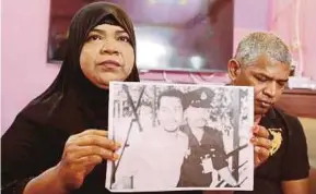  ?? PIC BY MIKAIL ONG ?? Hawa Jaafar holding a photo of her eldest brother, Adam, at her house in Sungai Ara, Bayan Lepas, yesterday. With her is her brother, Arman.