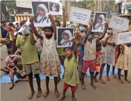  ?? — PRITAM BANDYOPADH­YAY ?? Street children pay floral tribute to Mother Teresa to celebrate her 111 birth anniversar­y in Kolkata on Thursday.