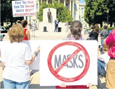  ?? AP ?? Protesters listen to William Kelly, host of the ‘Citizen Kelly Show’, as he speaks about suing Governor J.B. Pritzker over COVID-19 restrictio­ns during the ‘Million Unmasked March’ at the Illinois State Capitol in Springfiel­d on Saturday, July 25. The protesters gathered in front of the Abraham Lincoln Statue to voice their opposition to guidelines that children be required to wear face masks when they return to school during the COVID-19 pandemic.