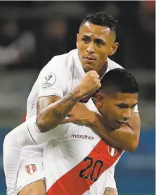 ?? Andre Penner / Associated Press ?? Peru’s Victor Yotun jumps on teammate Edison Flores’ back to celebrates Flores scoring Peru’s first goal against Chile.