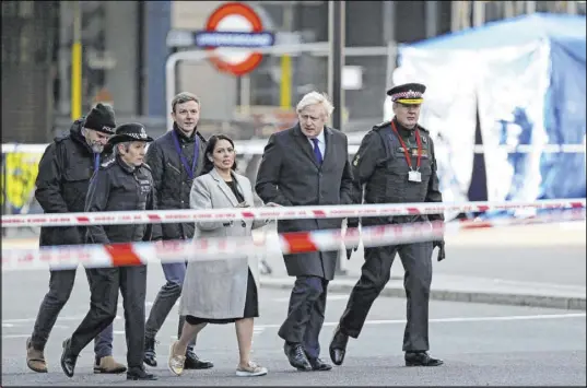  ?? Steve Parsons The Associated Press ?? Britain’s Prime Minister Boris Johnson, second from right, Home Secretary Priti Patel, center, and Metropolit­an Police Commission­er Cressida Dick, second from left, on Saturday view the scene of Friday’s attack on London Bridge.