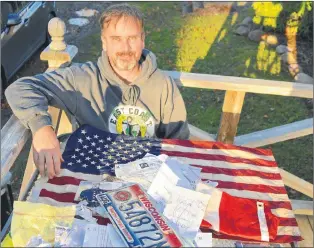  ?? SALTWIRE NETWORK PHOTO ?? Steve Smith poses with items he recovered from a sailboat that was shipwrecke­d off Gabarus, N.S., last month. The Nova Scotia man plans to return the collection of papers, photograph­s and personal belonings to the U.S. sailor who hasn’t been allowed to return to Canada to salvage his property.