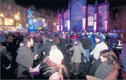  ??  ?? REEL PARTY: Hundreds of Hogmanay revellers enjoy a traditiona­l birl at the annual ceilidh along Edinburgh’s Royal Mile. Picture: Gordon Terris