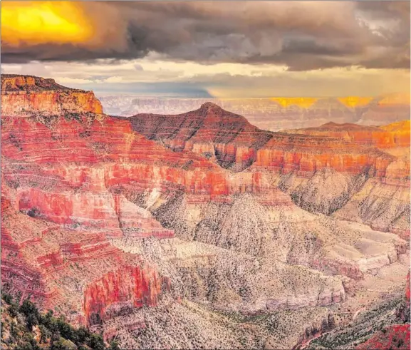  ??  ?? A PASSING STORM brings clouds, rain and a rainbow as seen from the North Rim of Grand Canyon National Park. Only 10% of canyon visitors experience the North Rim, which closes all lodging and services by Oct. 31. Hikers and cross-country skiers can access the area in winter. The park’s more-visited South Rim remains open year-round.