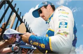  ?? TIM NWACHUKWU/GETTY ?? Chase Elliott signs autographs for fans in the garage area prior to Sunday’s race at Pocono Raceway in Long Pond, Pennsylvan­ia.