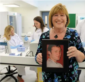  ??  ?? Maureen Kelly at the opening of the new laboratory in the Mater Hospital, holding a picture of her son Darragh, who died of Sudden Adult Death Syndrome. Photo: Caroline Quinn