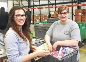  ?? SUBMITTED ?? Landscape and Greenhouse Management juniors, Sydney Collier (Clearview) and Ana Crum (Midview) sort food at Second Harvest Food Bank.