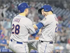  ??  ?? Todd Frazier, right, of the Mets celebrates with J.D. Davis after hitting a three-run homer in the top of the ninth inning against Philadelph­ia.