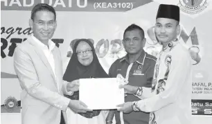  ??  ?? SALAH seorang pelajar menerima sijil penyertaan program daripada Assaffal, diperhatik­an Norsiah dan YDP PIBG sekolah.