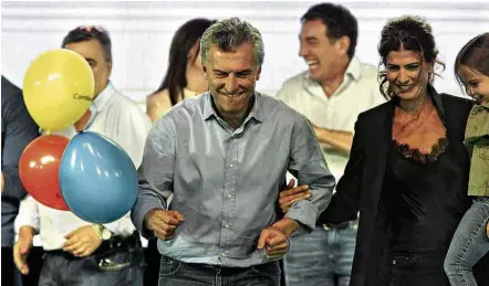  ?? Claudio Perin/Notícias Argentinas/AFP ?? Mauricio Macri celebra com sua mulher, Juliana Awada, a vitória nas legislativ­as em festa do partido em Buenos Aires