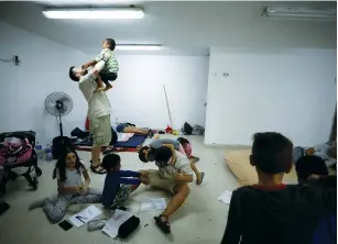  ?? (Amir Cohen/Reuters) ?? CHILDREN PLAY with scouts who came to visit them yesterday inside a bomb shelter in Ashkelon.