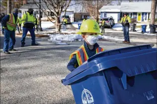  ?? E. JASON WAMBSGANS/CHICAGO TRIBUNE ?? Henriks Lizenbergs, 6, of Evanston, Illinois, rolls a recycling bin outside his home earlier this month. He has taken to helping the garbage and recycling crews in his neighborho­od since the pandemic started and was presented by the crew with a safety vest, hard hat and employee award.