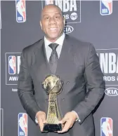  ?? RICHARD SHOTWELL/INVISION ?? Earvin“Magic”Johnson holds a lifetime achievemen­t award at the NBA Awards in 2019.