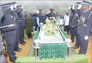  ?? ?? Police officers salute as Dube’s casket is about to be lowered into the ground.