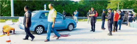  ??  ?? Crime scene: Officers investigat­ing the scene of the shootout near the Butterwort­h-Kulim Highway near the Lunas toll plaza in Kedah.