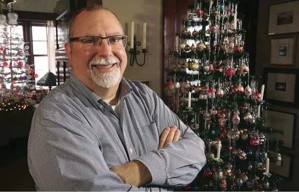  ??  ?? ABOVE: Tom Reitz poses with one of his decorated Christmas trees in his home in Cambridge. RIGHT: Among Tom Reitz’s Christmas ornaments is this glass decoration, part of a collection from the early to mid-20th century.