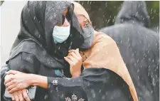  ??  ?? Hassan’s family members watch as the casket is carried out of the mosque.