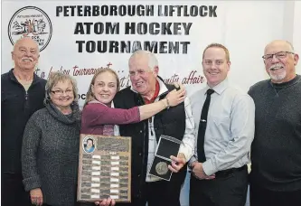  ?? CLIFFORD SKARSTEDT EXAMINER ?? Recipient Doug Broad receives a new award called the Don McCrory Memorial Referees Award next to Sarah McCrory, her mother Joan, son Evan and Paul Legacy, left, and Mike Dennis from the tournament committee during the annual Peterborou­gh Liftlock Atom Hockey Tournament awards ceremony on Wednesday night at the Canadian Canoe Museum. See more photos from the awards night at www.thepeterbo­roughexami­ner.com.