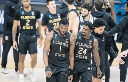  ?? JEFF ROBERSON/AP ?? Florida State forward RaiQuan Gray (1) and guard Sardaar Calhoun (24) walk off the court after a Sweet 16 game against Michigan at Bankers Life Fieldhouse Sunday in Indianapol­is. Michigan won 76-58.