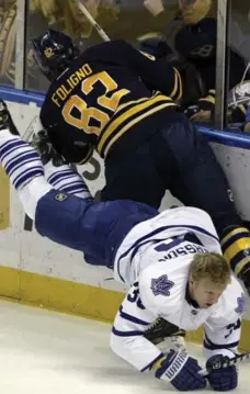  ?? DEVIN DUPREY/AP ?? Buffalo rookie Marcus Foligno levels Carl Gunnarsson early in the first period Tuesday, leaving the Leaf blueliner with a separated shoulder.