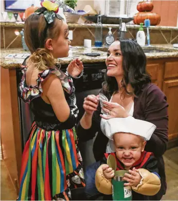  ?? Steve Gonzales / Staff photograph­er ?? Alicia Ackley helps her children Tatum, 5, and Joshua, 1, get ready for Halloween. Ackley, 32, says she’s glad she had open surgery for cervical cancer rather than a minimally invasive operation.