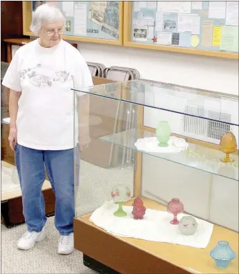  ?? Keith Bryant/The Weekly Vista ?? Volunteer docent Winnie Leonard looks at the fairy lamps on display in the Bella Vista Historical Museum.