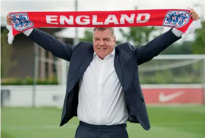  ?? AFP ?? Sam Allardyce holds up an England scarf during a photocall at St George’s Park.—