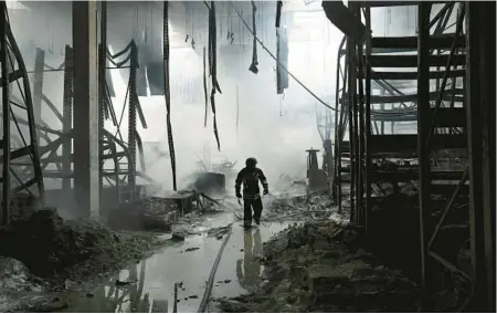  ?? GENYA SAVILOV/GETTY-AFP ?? A firefighte­r walks amid the ruins of a shopping mall hit by Russian shells Friday in Kherson, Ukraine.