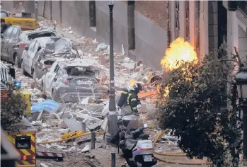  ?? MANUFERNAN­DEZ/AP ?? Deadly explosion in Spain: Firefighte­rs work near a damaged building Wednesday after a gas explosion in Madrid. The blast killed at least four people, injured 11 and left rubble across a nearby schoolyard. The building belongs to a Catholic parish and hosted offices and apartments for some of its priests, Madrid Archbishop Carlos Osoro said.