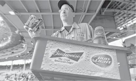  ?? Paul Beaty / Associated Press file ?? A beer vender makes his way through the stands at Chicago’s Wrigley Field last year selling Budweiser and Bud Light. Anheuser-Busch InBev has received regulatory approval in 23 places for its purchase of SABMiller, including the United States.